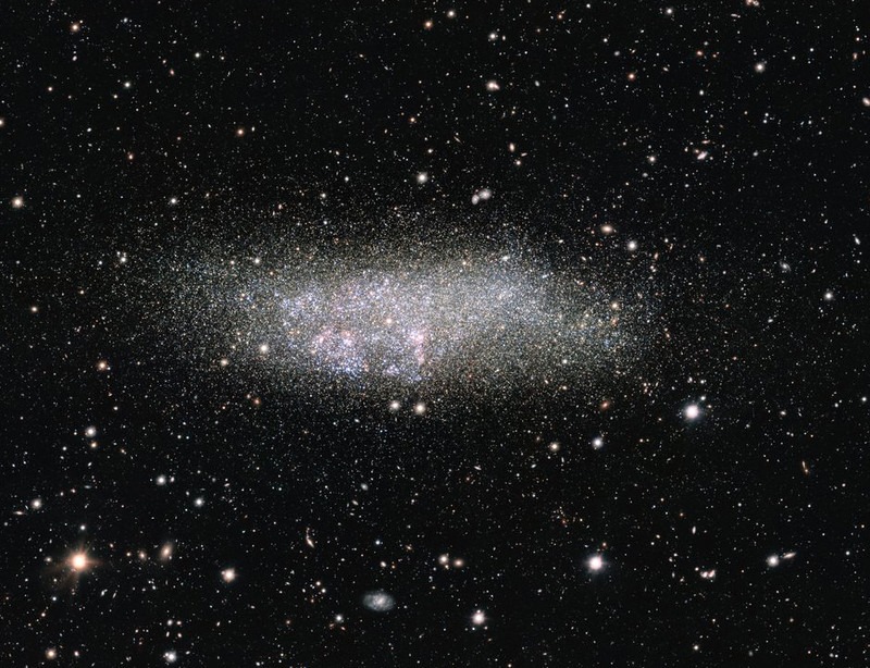 This image, captured by ESO’s OmegaCAM on the VLT Survey Telescope, shows a lonely galaxy known as Wolf-Lundmark-Melotte, or WLM for short. Although considered part of our Local Group of dozens of galaxies, WLM stands alone at the group’s outer edges as one of its most remote members. In fact, the galaxy is so small and secluded that it may never have interacted with any other Local Group galaxy — or perhaps even any other galaxy in the history of the Universe.